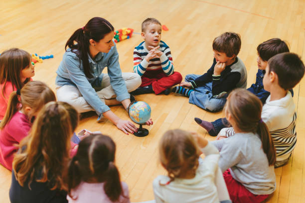 istock Preschool teacher and children in classroom 506065464