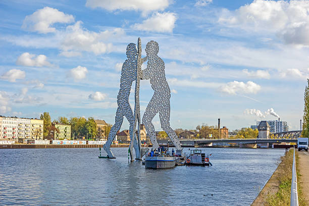 Molecule Man sculpture Berlin, Germany - October 29, 2013: Molecule Man sculpture by Jonathan Borofsky. The sculpture represent the intersection of the districts Treptow, Kreuzberg and Friedrichshain. Boats in front. friedrichshain photos stock pictures, royalty-free photos & images