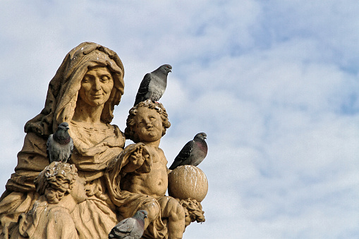Pigeons Taking Rest on a Statue of a Woman and Children - Prague, Carl's Bridge