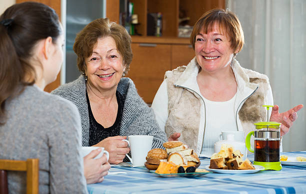 istock Senior women talking with girl while tea drinking 506066556