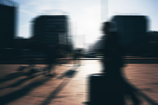 Blurred defocused picture of people walking outdoor on the sidewalk in the city - commute, work concept