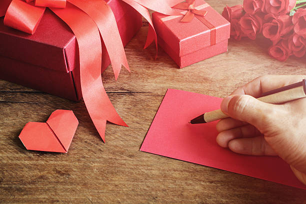 istock Hand writing on notebook with red gift box and flower 506069468