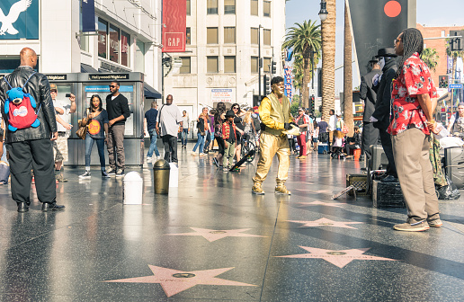 Los Angeles, United States - March 21, 2015: street artists and everyday multiracial people around the world famous Walk Of Fame in late afternoon on Hollywood Boulevard in LA California - United States of America