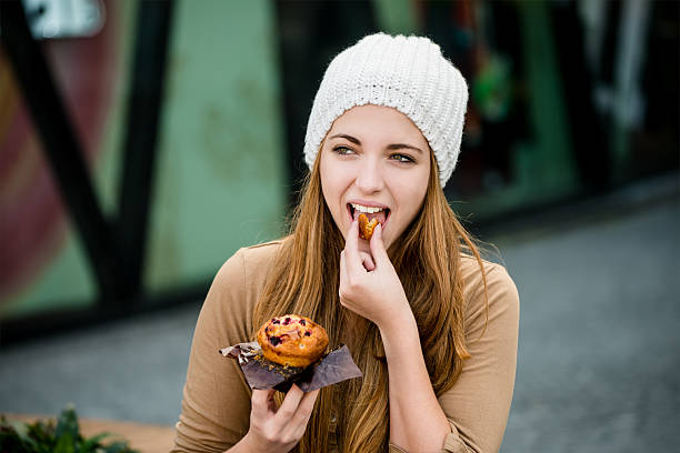 Teenager eating  muffin stock photo