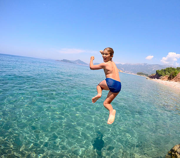 istock Boy jumping into the sea 506100260