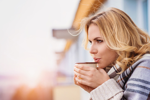 Beautiful woman relaxing at home with cup of  coffee