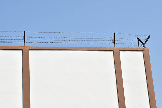 istock the prison walls with high walls and barbed iron wire 506103124