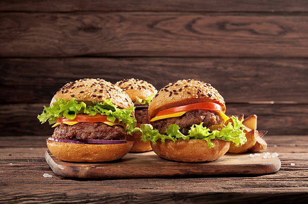 istock three different burgers on wooden background 506103548