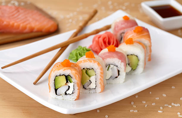 Rainbow dragon sushi roll with salmon, avocado, soft cheese, cucumber stock photo