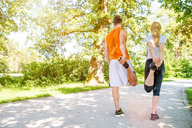 istock Rear view of couple stretching before running in a park. 506105375