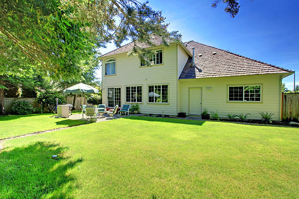 istock SUny green backyard with yellow hosue. 506105659