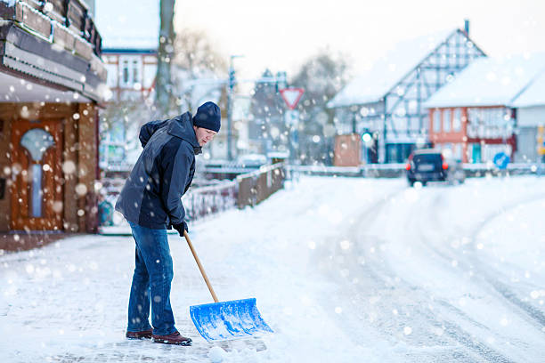 istock Man with snow shovel cleans sidewalks in winter 506105702