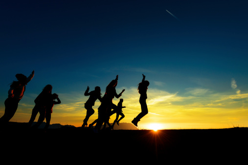 group of friends at sunset jumping and having fun.