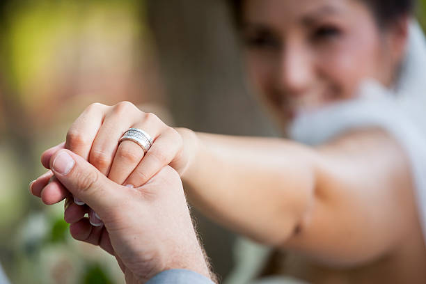 istock Groom holding a bride's hand with the wedding ring 506105990