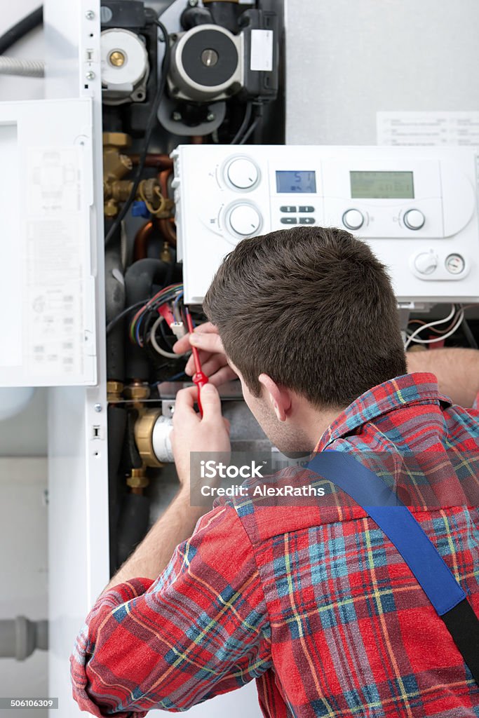 Technician servicing heating boiler Technician servicing the gas boiler for hot water and heating House Stock Photo