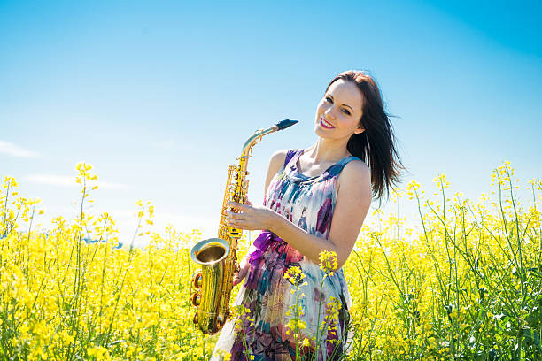 istock Woman with saxophone in rapeseed field 506115782
