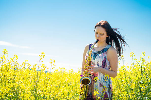 istock Woman playing saxophone in rapeseed field 506117104