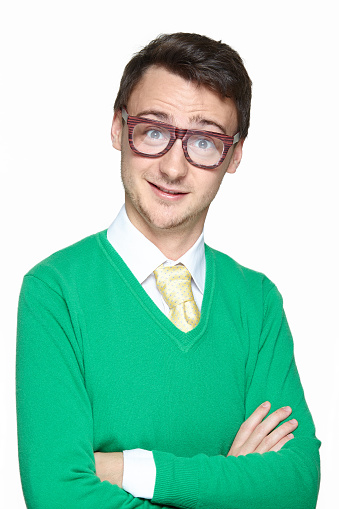 Portrait of smiling weird young man wearing big eyeglasses and holding arms crossed isolated on white background. Surprised nerd.