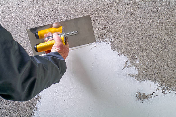 edilizia operaio-plastering e appianare parete di cemento - plaster plasterer wall repairing foto e immagini stock