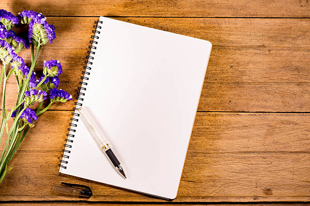 istock Blank Notebook with Flower on Wooden Table 506120984