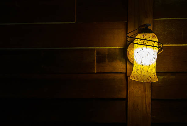 istock Lamp Shade from Illuminated Lamp at Corner on Wooden Wall 506123484