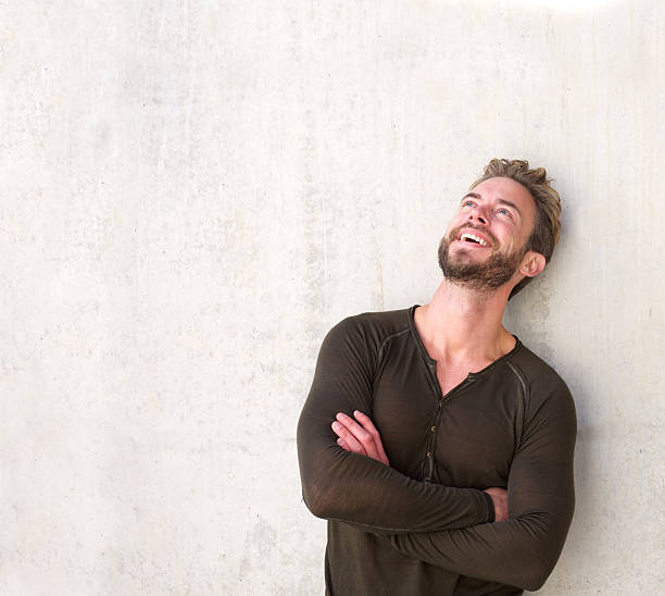 istock Laughing handsome man with arms crossed looking up 506124562