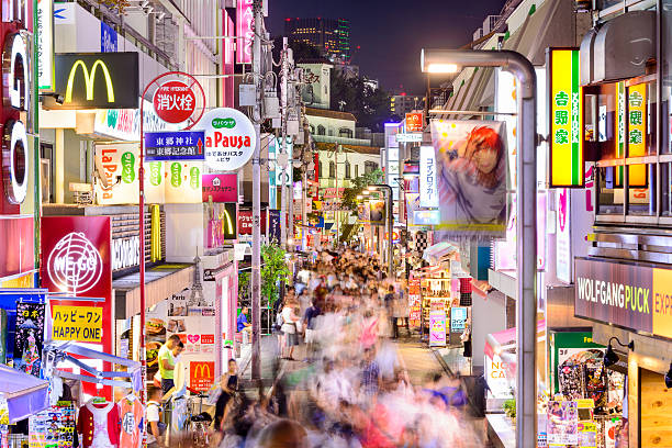 Harajuku District of Tokyo Tokyo, Japan - August 6, 2015: Crowds walk through Takeshita Street in the Harajuku district at night. Harajuku is a center of Japanese youth culture and fashion. tokyo harajuku stock pictures, royalty-free photos & images
