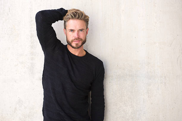 Male fashion model posing with hand in hair Portrait of a male fashion model posing with hand in hair black men with blonde hair stock pictures, royalty-free photos & images