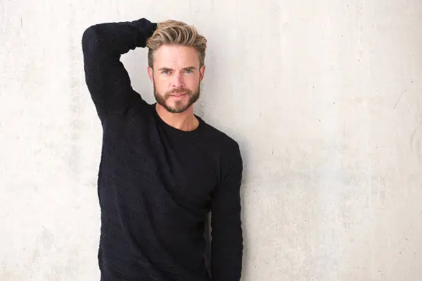 Photo of Male fashion model posing with hand in hair