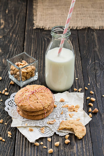 biscoitos de pasta de amendoim, leite, amendoim, em superfície de madeira escura - nobody food canvas peanut - fotografias e filmes do acervo
