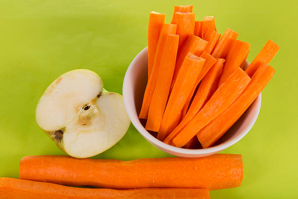 fresh carrots apple on a green background
