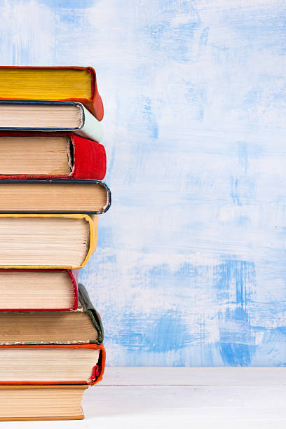 istock Stack of colorful hardback books, open book on blue background 506130474
