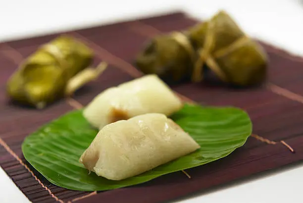 Thai traditional sticky rice dessert in banana leaf packaging.