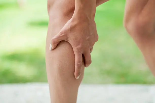 Woman holding sore leg muscle