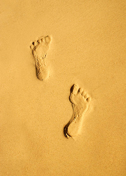 istock pair of human footprints on the sand 506133974