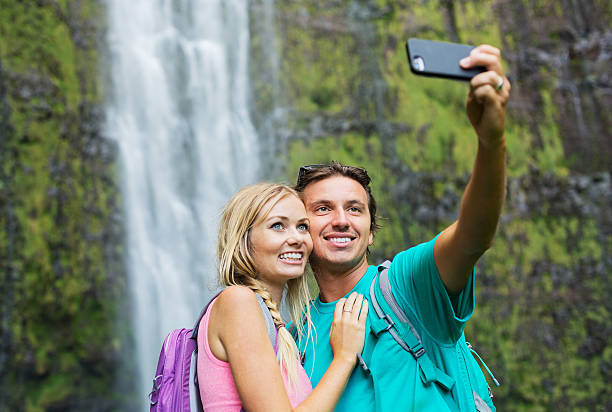 カップルが一緒に屋外での楽しいと一緒にハイキング - maui waterfall hawaii islands hana ストックフォトと画像