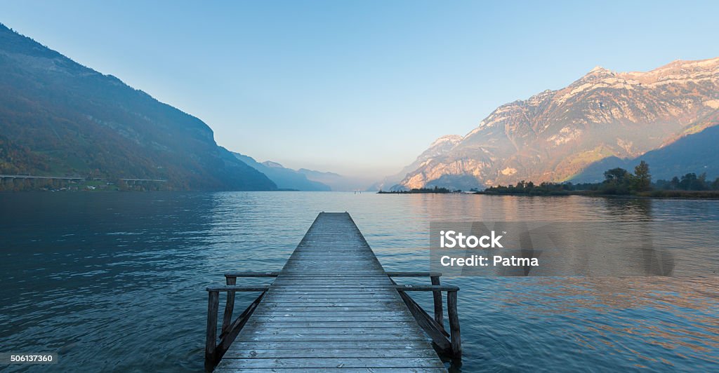 pier Wooden pier on the lake. Sunset in pastel colors. Mountains in the background. Backgrounds Stock Photo