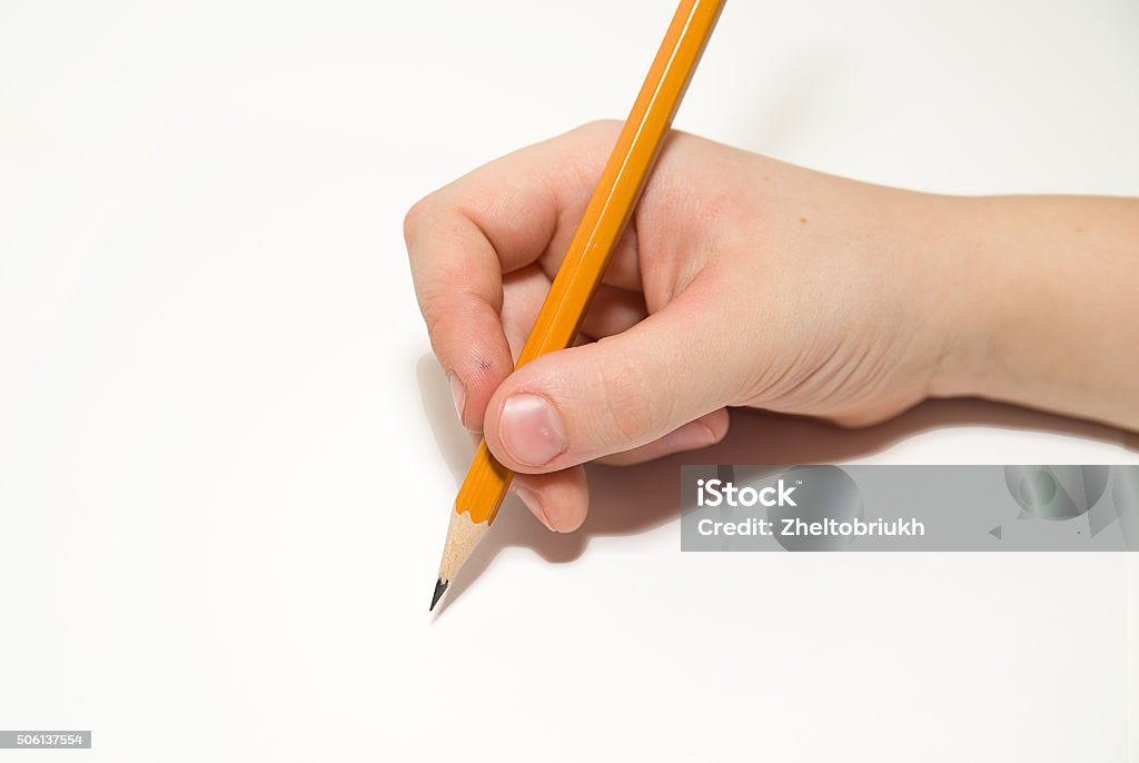 Kid's rigth hand holding a pencil on over white Kid's rigth hand holding a pencil on a white Blade Stock Photo