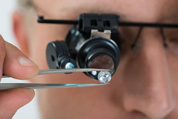 personne examinant avec loupe à grossissement diamond - diamond jeweller jewelry examining photos et images de collection