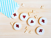 Linzer cookies with cherry jam on the wooden table