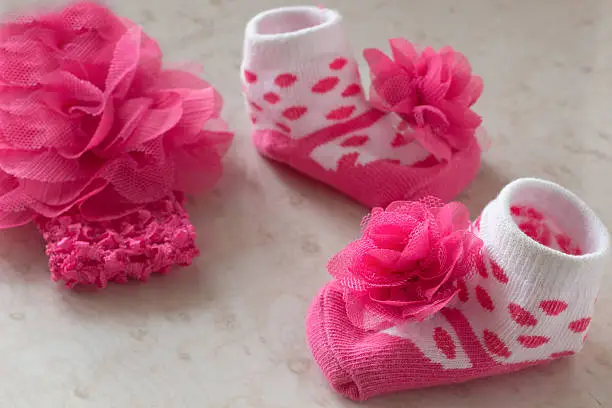 White socks in pink polka dots and a flower for the baby on the table