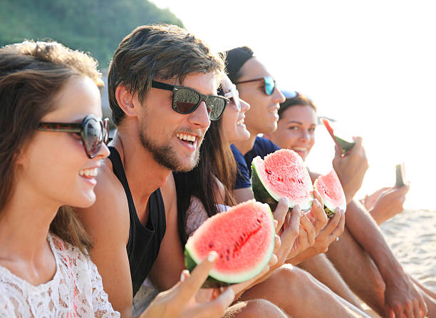 istock Friends eating watermelon on beach 506143564