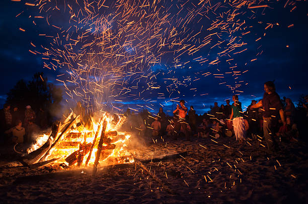 night campfire Leningrad Oblast, Russia - July 14, 2015: Big  tourist bonfire on the beach Finland Gulf during the festival. Young people dance and sing around the campfire. Deep night. baltic sea people stock pictures, royalty-free photos & images