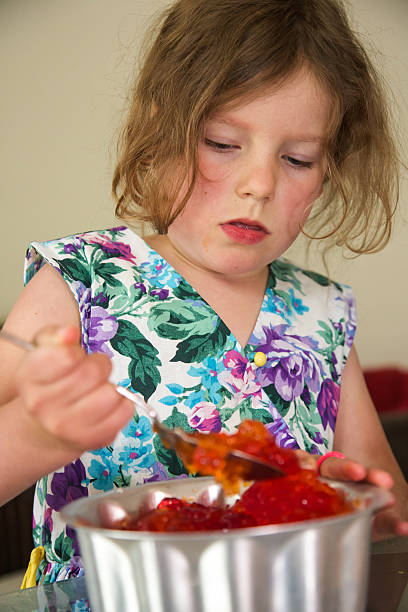 istock Young child having fun eating jelly from a spoon 506146336