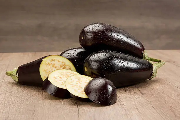 Fresh eggplants on wood table.