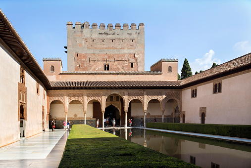 Granada, Spain – September 8, 2015: View of the north portico of the Court of the Myrtles with tourists admiring the fabulous art work, in The Alhambra