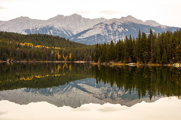 Montanhas e árvores refletido no Lago Pirâmide - foto de acervo