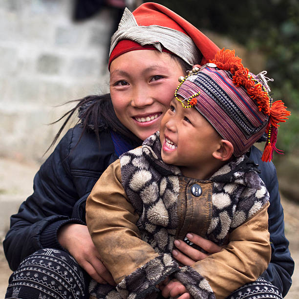 Happy Hmong Hill Tribe Woman and Child, Sapa, Vietnam Happy Hmong woman and child smiling, sitting outside their house at Giang Ta Chai village near the hill town of Sa Pa, Lao Cai Province, North Vietnam. miao minority stock pictures, royalty-free photos & images