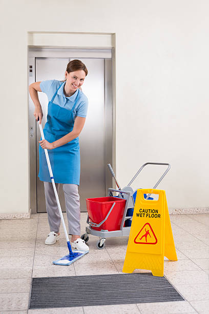 istock Worker With Cleaning Equipments And Wet Floor Sign 506160258
