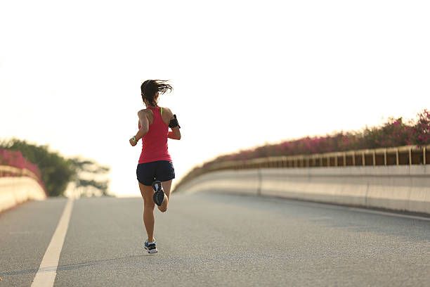 istock young woman runner running on city bridge road 506160320